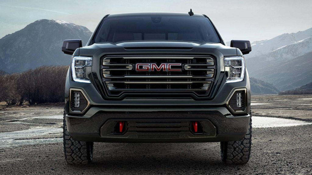GMC Sierra 1500 AT4 bold front view with red tow hooks in rugged mountain off-road setting wallpaper