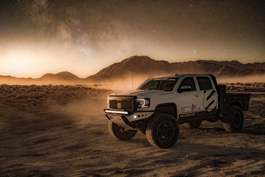 White GMC Sierra pickup truck parked in desert under starry night sky rugged adventure wallpaper