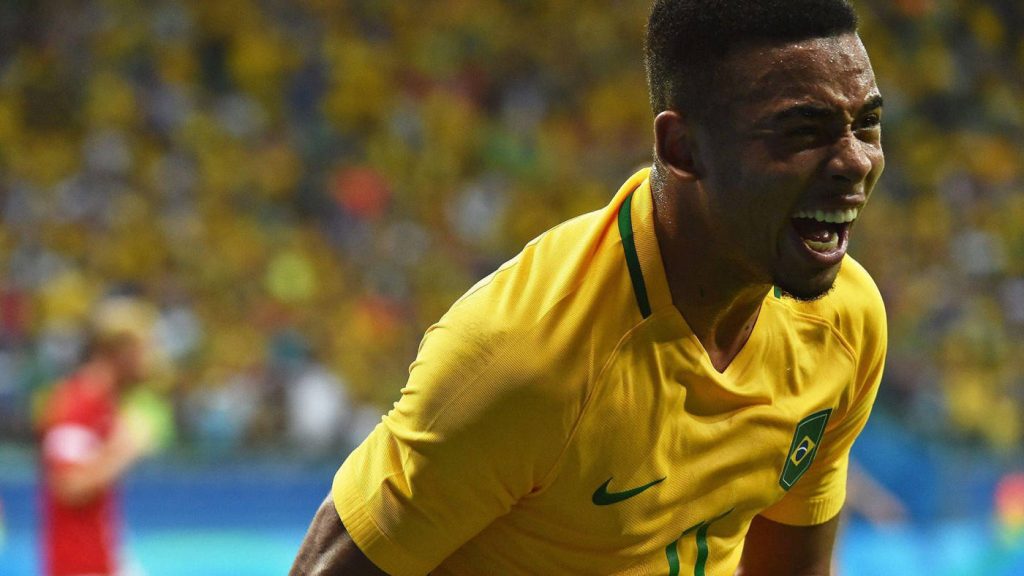 Gabriel Jesus celebrating goal in Brazil football kit vibrant stadium background wallpaper