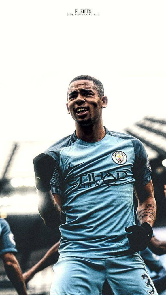 Gabriel Jesus celebrating in Manchester City kit with intense energy and blurred stadium background Wallpaper