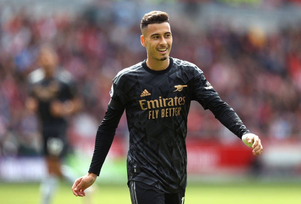 Gabriel Martinelli smiling in Arsenal black away kit on pitch with blurred stadium background wallpaper