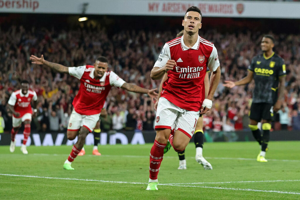 Gabriel Martinelli celebrates Arsenal goal with cheering fans and teammates in vibrant stadium background Wallpaper