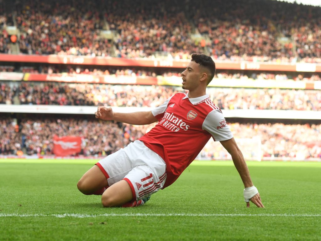 Gabriel Martinelli Arsenal forward knee slide celebration in red white kit on stadium pitch wallpaper
