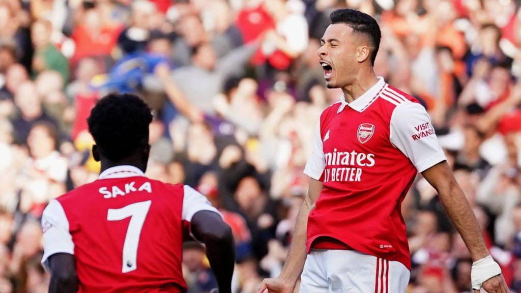 Gabriel Martinelli celebrates Arsenal win shouting with Bukayo Saka vibrant red white kit stadium background Wallpaper