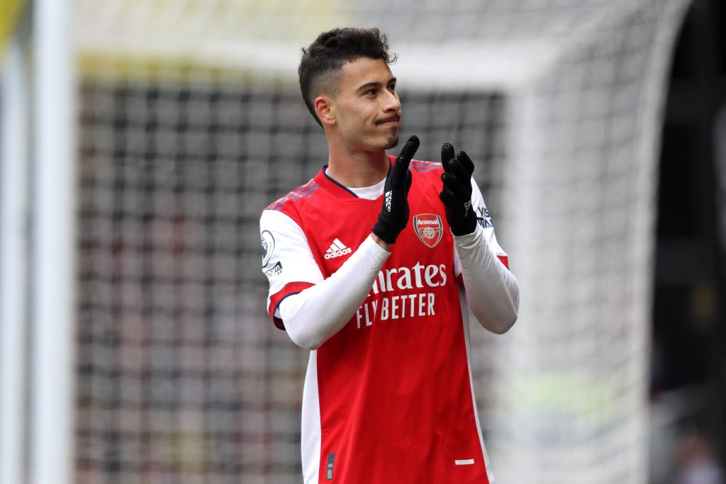 Arsenal Gabriel Martinelli clapping on pitch in red white kit with blurred goalpost background Wallpaper