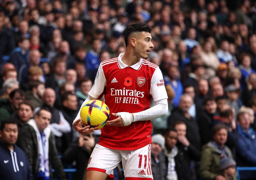 Gabriel Martinelli Arsenal number 11 kit holding match ball mid-game stadium crowd background Wallpaper