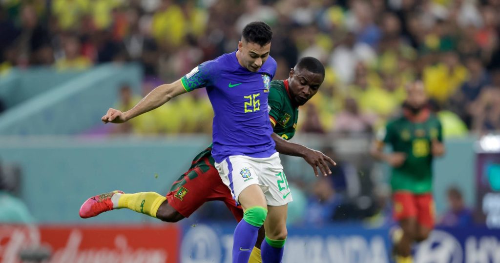Gabriel Martinelli in No 26 jersey dribbling past Cameroon defender in stadium lights wallpaper