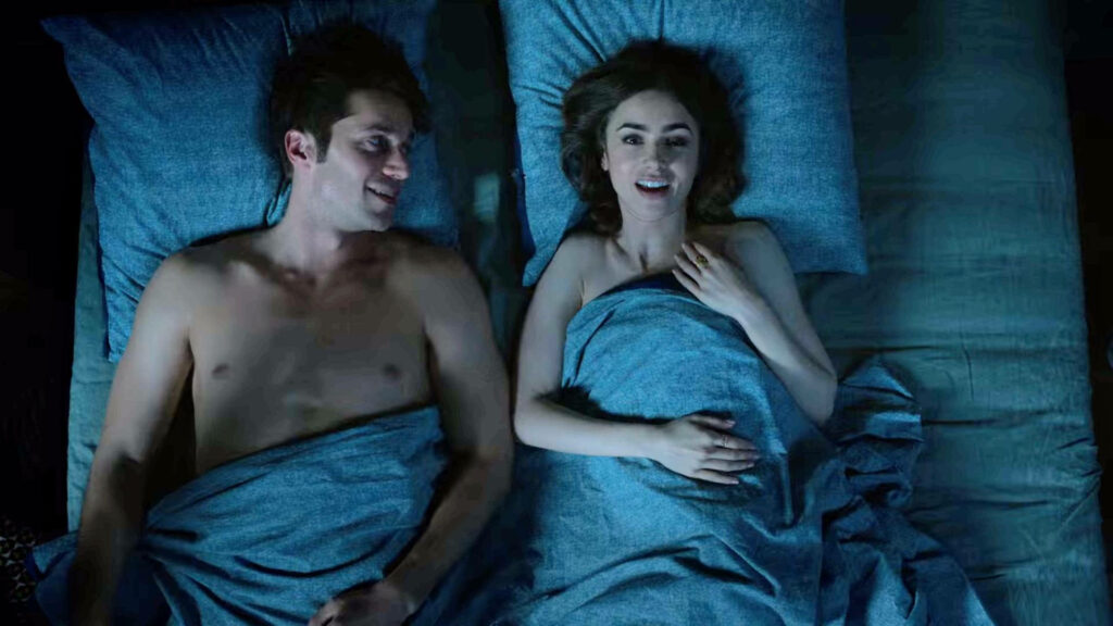 Gabriel and Emily sharing an intimate moment in bed under blue sheets Emily In Paris wallpaper