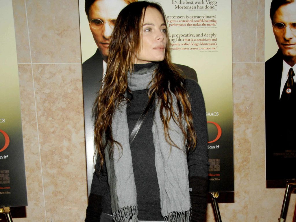 Gabrielle Anwar in dark turtleneck and scarf at event with Good 2008 movie poster background Wallpaper