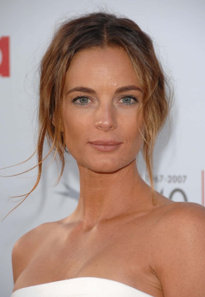 Gabrielle Anwar in elegant white strapless dress with soft lighting at a press event wallpaper