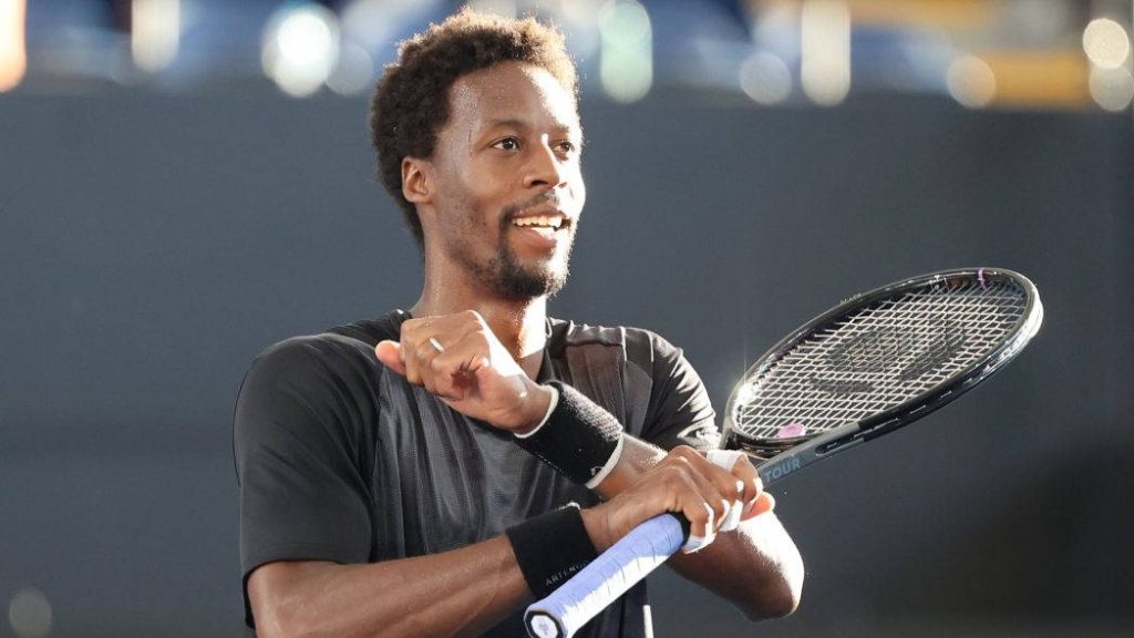 Tennis star Gaël Monfils celebrating with racket black gear sunlit joyful expression stadium background Wallpaper