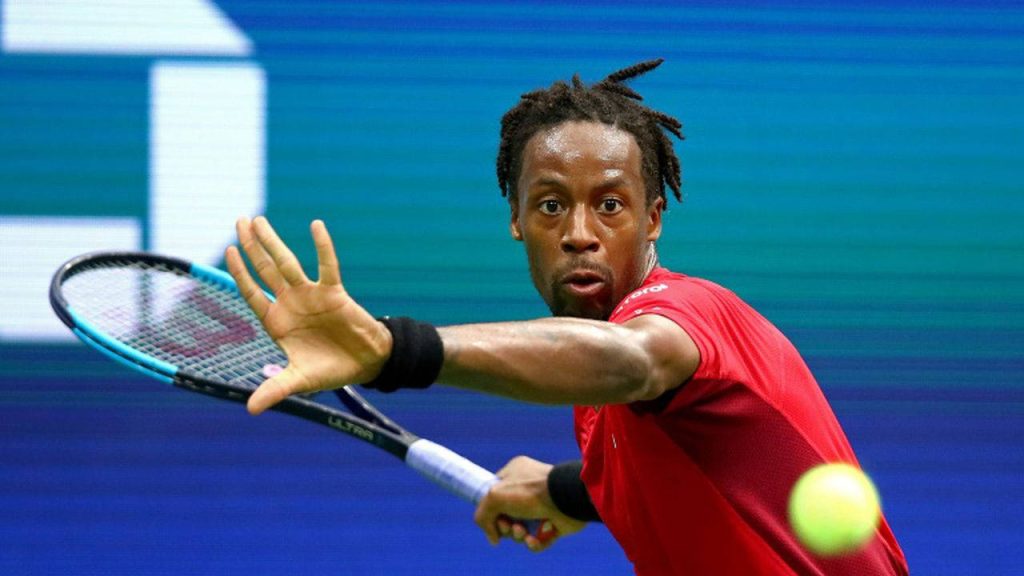 Gael Monfils mid forehand tennis swing in red kit on vibrant blue hard court wallpaper
