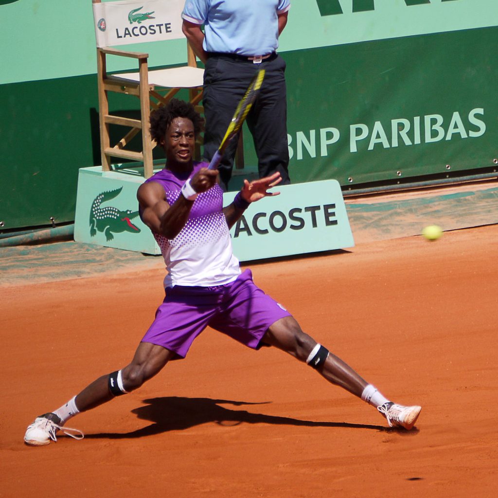 Gaël Monfils lunging for a backhand on red clay at Roland Garros tennis tournament wallpaper background