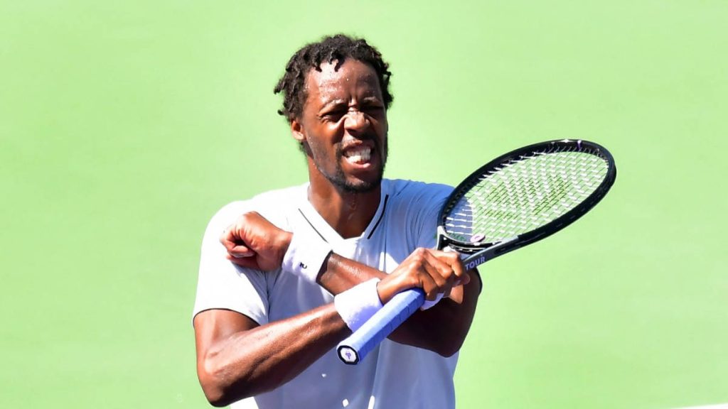 Tennis star Gaël Monfils mid-action on green hard court showing intense focus and power Wallpaper