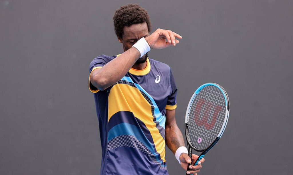 Gaël Monfils wiping sweat holding Wilson racket in patterned Asics kit tennis wallpaper