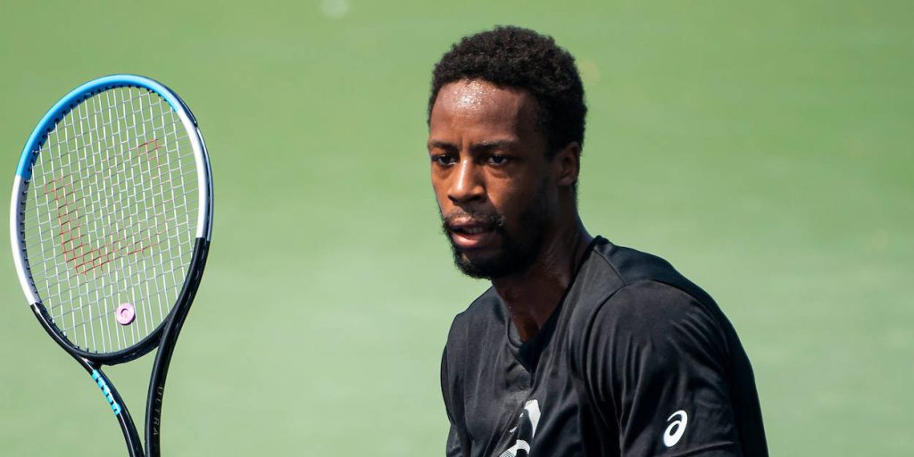 Tennis star Gaël Monfils intense focus black shirt vibrant green court crisp natural light Wallpaper
