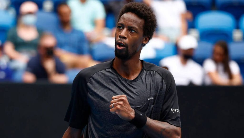 Tennis star Gaël Monfils in black shirt celebrating a point with clenched fist in stadium Wallpaper