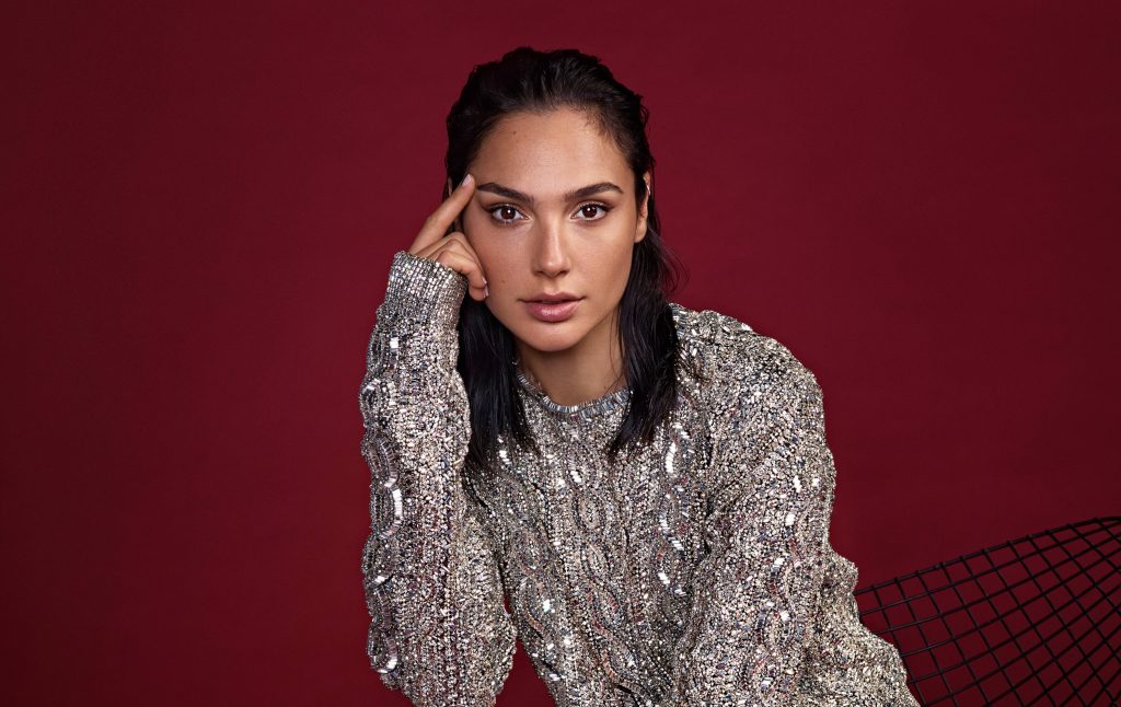 Gal Gadot studio portrait wearing embellished silver top with slicked-back hair on red background Wallpaper