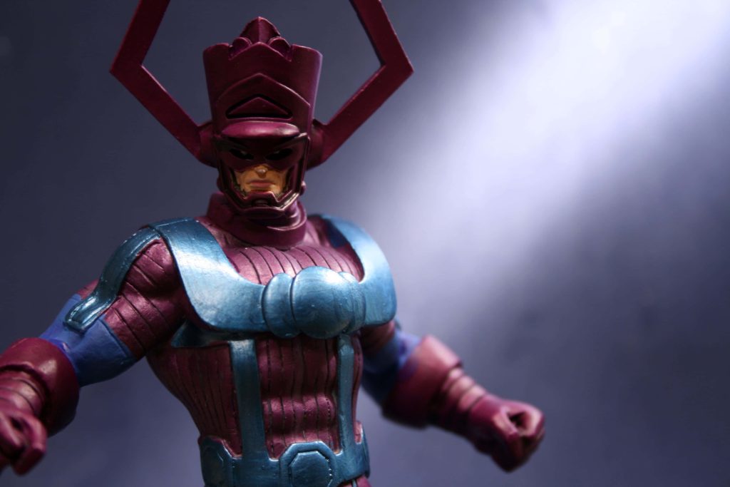 Macro close-up of Marvel supervillain Galactus action figure in purple blue armor with helmet Wallpaper