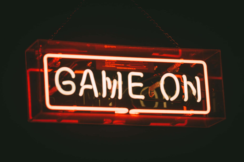 Creating a Riveting Digital Atmosphere: Illuminated 'Game On' Text Shines Through Brilliant Red Glass on Cutting-Edge Laptop Wallpaper