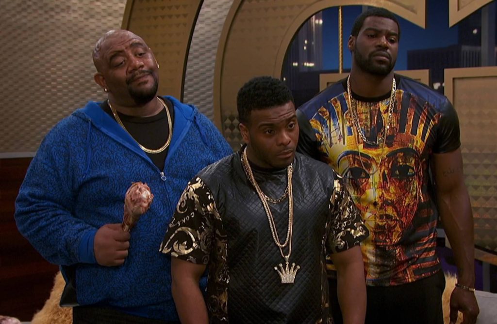 Game Shakers Double G and crew in gold hip-hop attire with turkey leg in luxury studio background Wallpaper