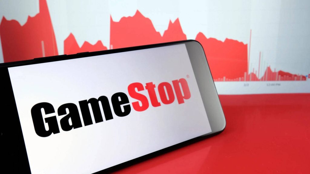 Smartphone showing GameStop logo with red stock market graph background for investors Wallpaper