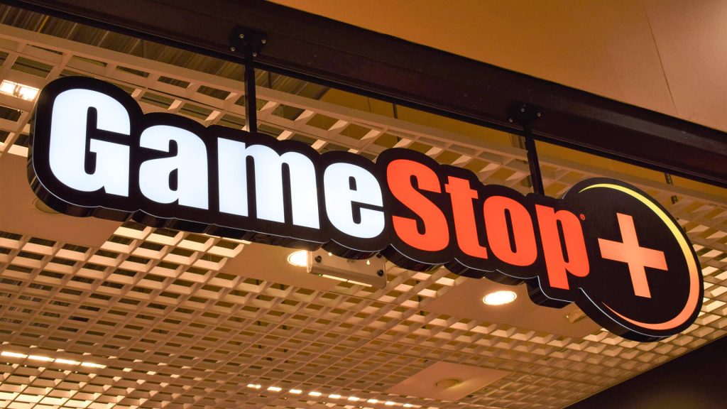 High-res wallpaper of illuminated GameStop store sign with metal grid ceiling background