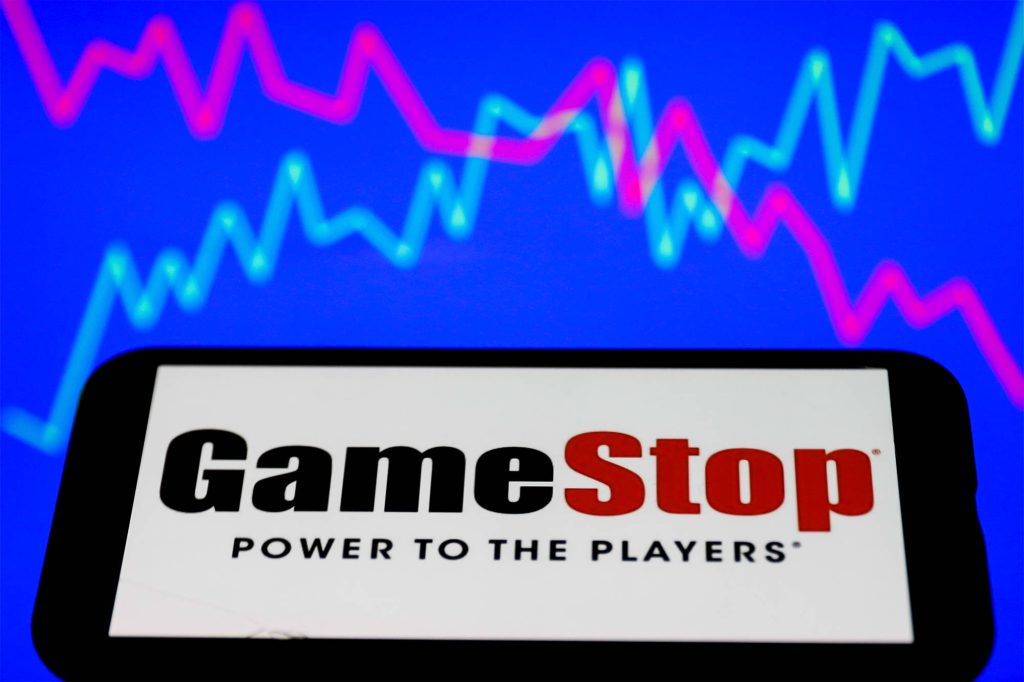GameStop logo with Power to the Players tagline on neon pink and blue stock market graph wallpaper