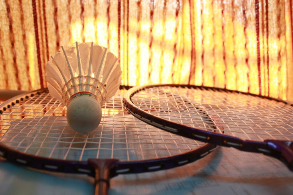 Games of Flight: Shuttlecock Takes Flight with a Dynamic Duo of Badminton Racquets Wallpaper