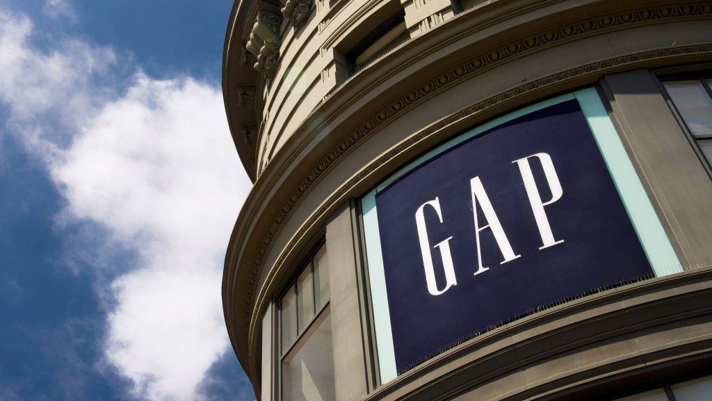 Low angle photo of San Francisco Gap store with navy logo on ornate curved tan building facade Wallpaper