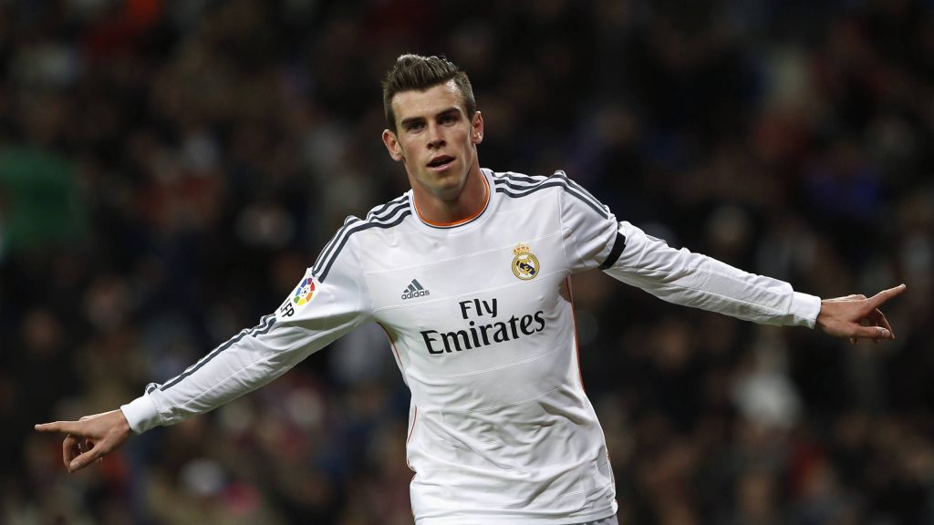 Gareth Bale celebrating in Real Madrid kit with blurred energetic stadium background wallpaper