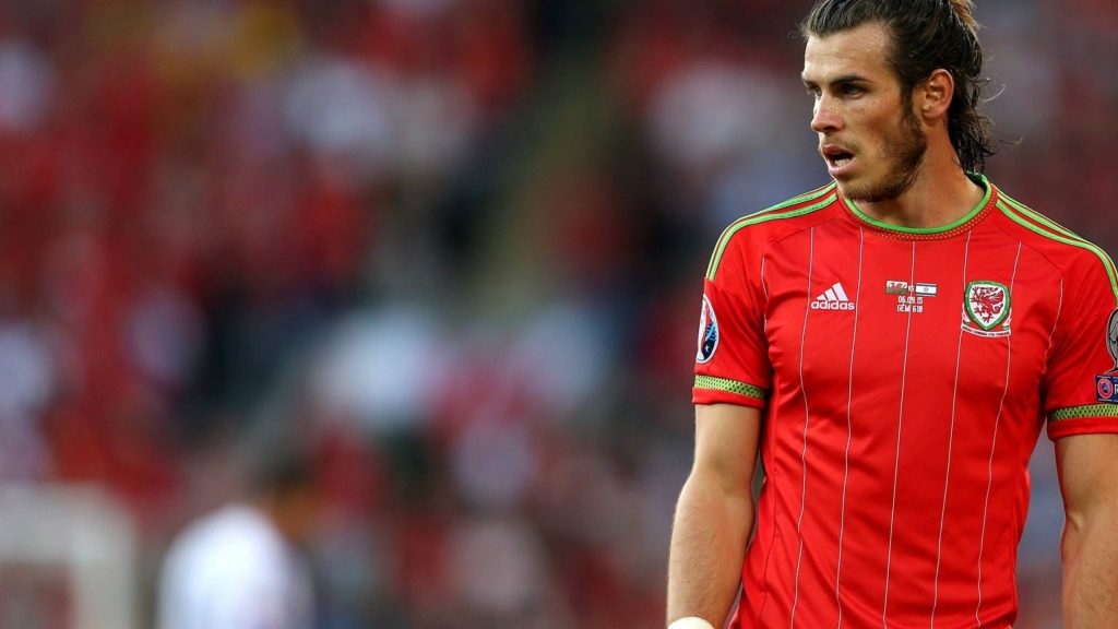 Gareth Bale in red Adidas Wales kit on pitch with blurred stadium crowd football wallpaper