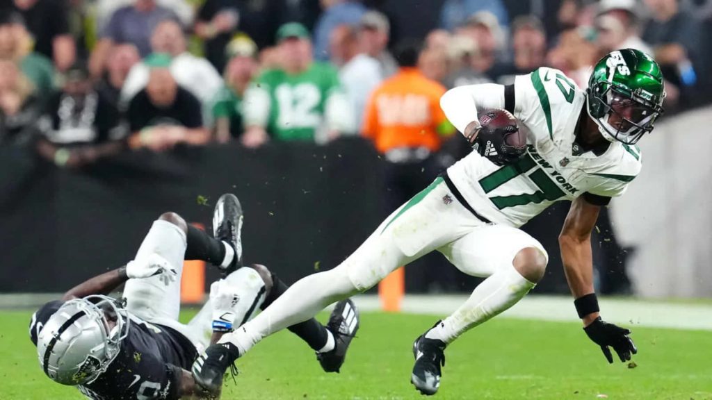 Garrett Wilson No 17 New York Jets dodging Las Vegas Raiders defender NFL action wallpaper