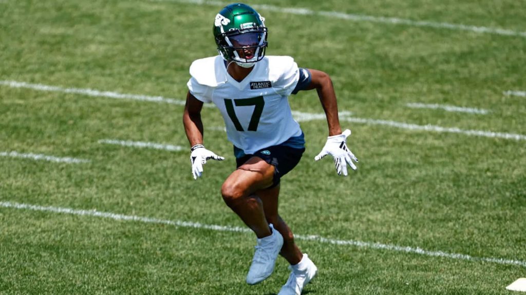 Garrett Wilson New York Jets wide receiver sprinting in white number 17 jersey and green helmet training Wallpaper