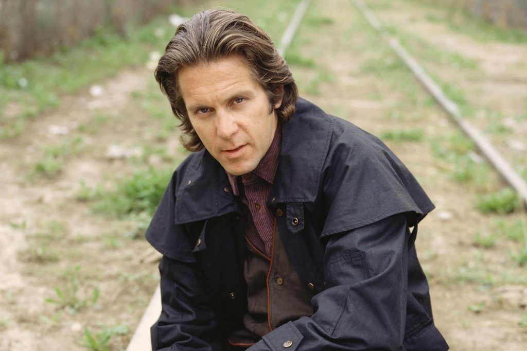 Pensive Gary Cole in dark jacket outdoors near railroad tracks medium close-up portrait wallpaper