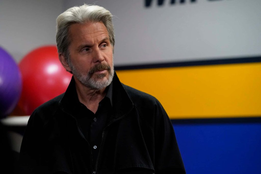 Gary Cole portrait in black jacket with grey hair beard red exercise ball vibrant wall accents wallpaper