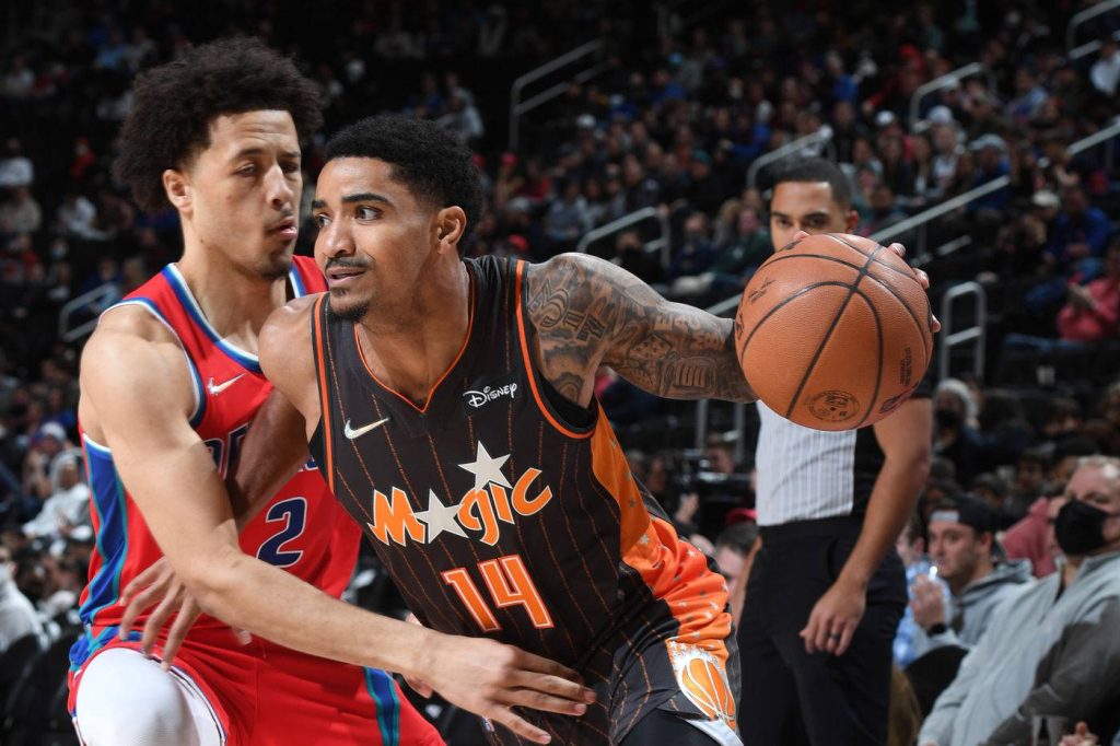 Gary Harris driving past Cade Cunningham in intense Orlando Magic vs Detroit Pistons NBA action Wallpaper