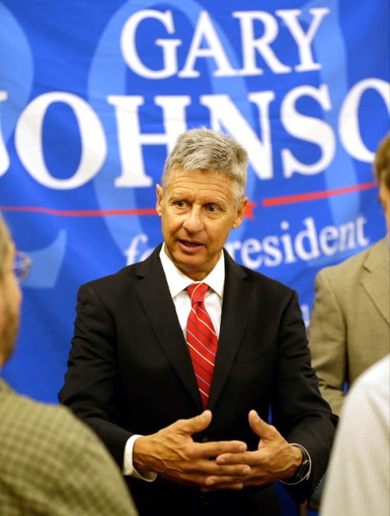 Gary Johnson in sharp suit red tie candid photo blue campaign banner phone wallpaper background