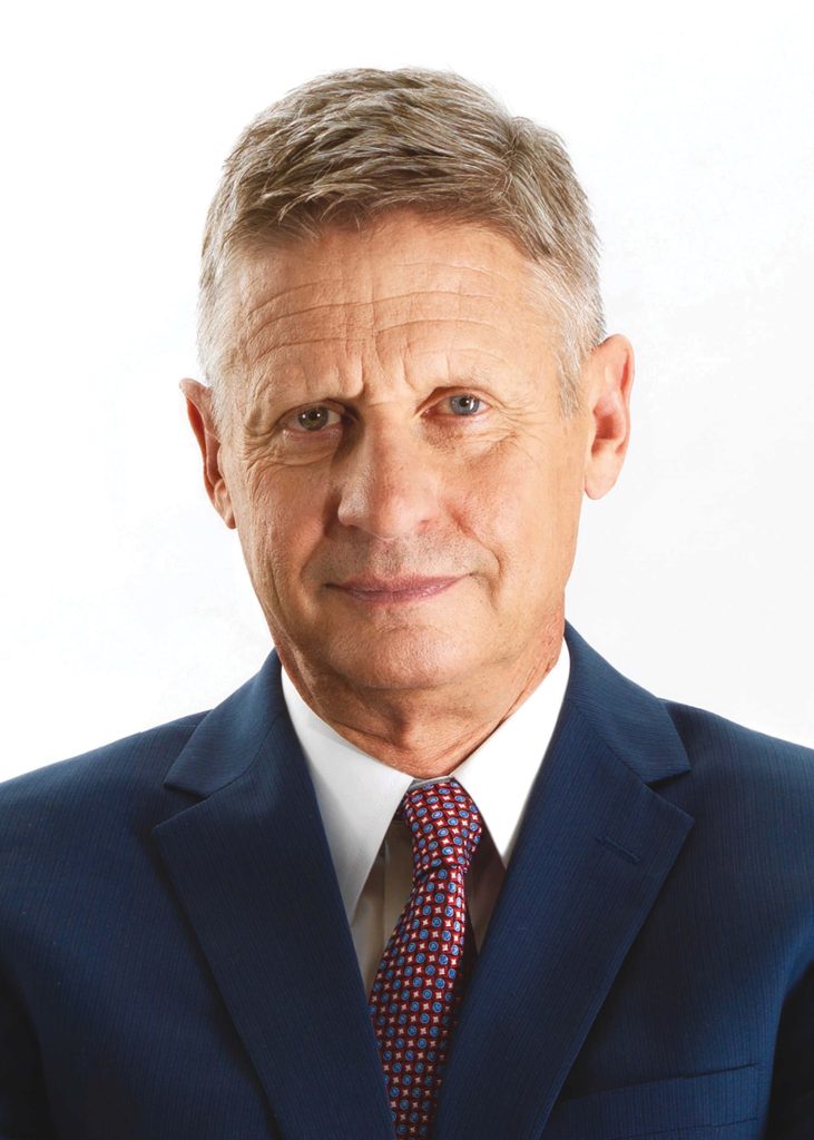 Gary Johnson professional portrait in navy suit red tie minimalist white background wallpaper