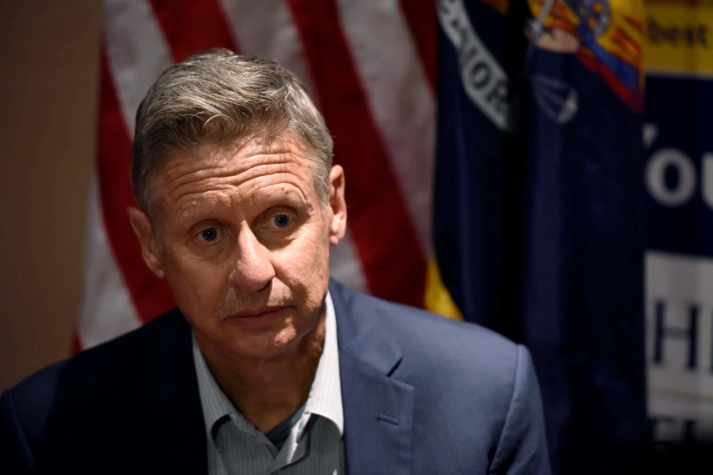 Professional portrait of former Governor Gary Johnson in dark blue suit with US flag background Wallpaper