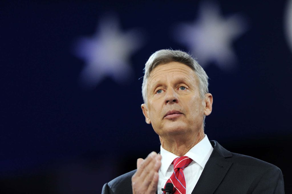 Gary Johnson speaking in formal suit red tie patriotic backdrop stars political wallpaper