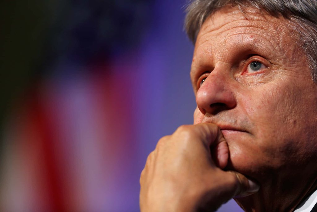 Portrait of Gary Johnson in thoughtful pose with American flag blurred background wallpaper