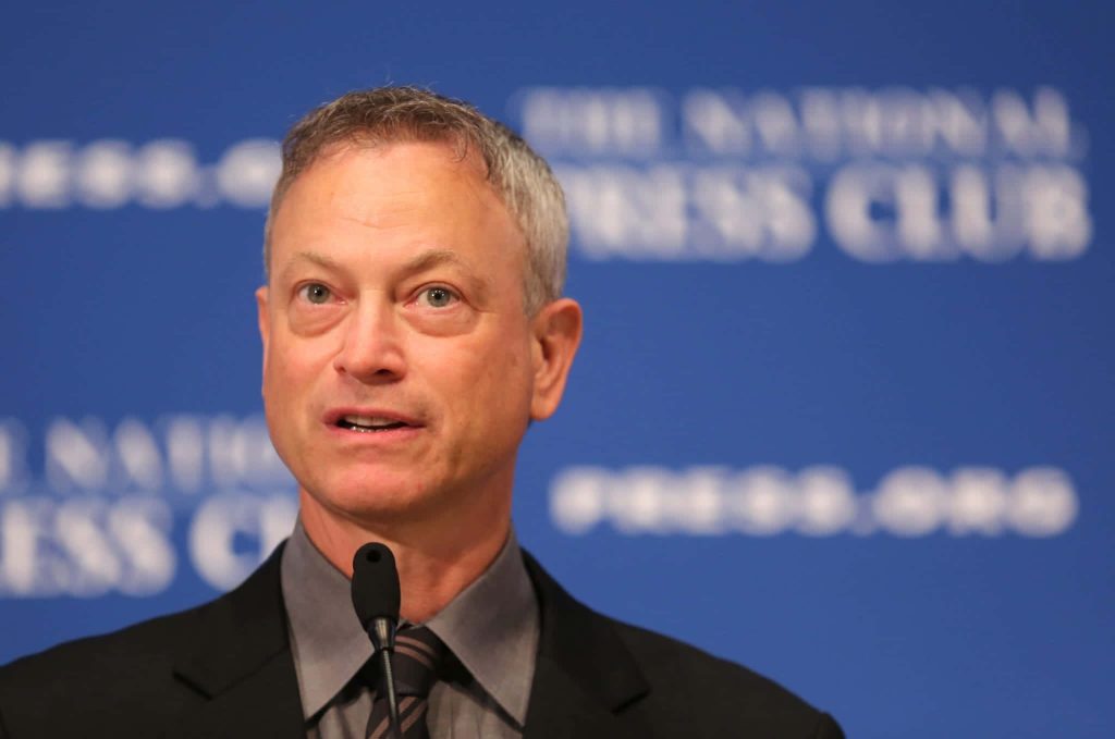 Gary Sinise speaking at National Press Club professional portrait with blue backdrop wallpaper