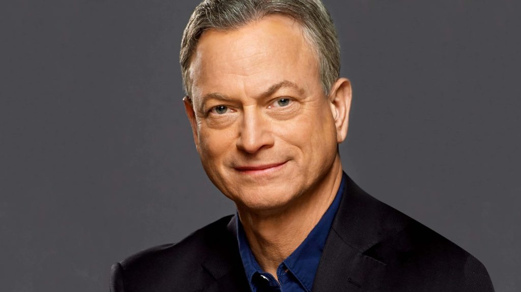 Gary Sinise professional portrait in dark blazer blue shirt against neutral grey background wallpaper
