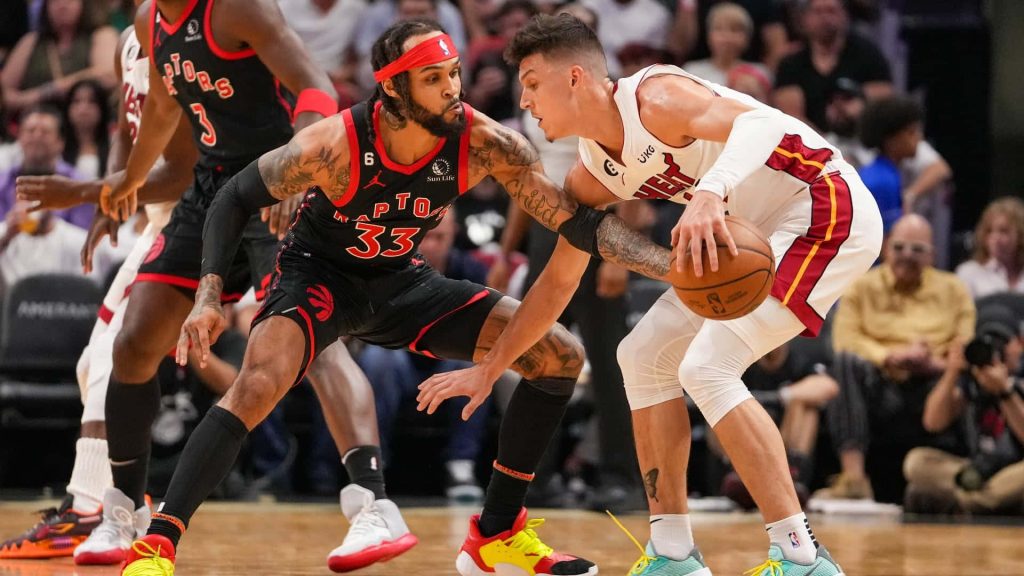 Gary Trent Jr defense against Tyler Herro NBA game hardwood court arena lighting wallpaper