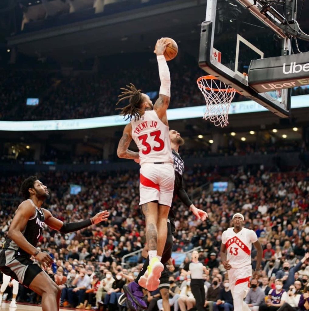 Gary Trent Jr. mid-air dunk Raptors vs Kings NBA action Pascal Siakam background wallpaper