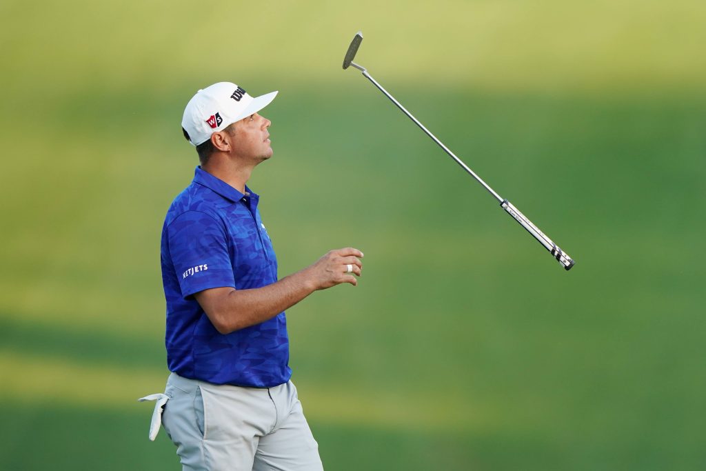 Gary Woodland frustrated tosses putter in blue polo on green golf course PGA wallpaper background