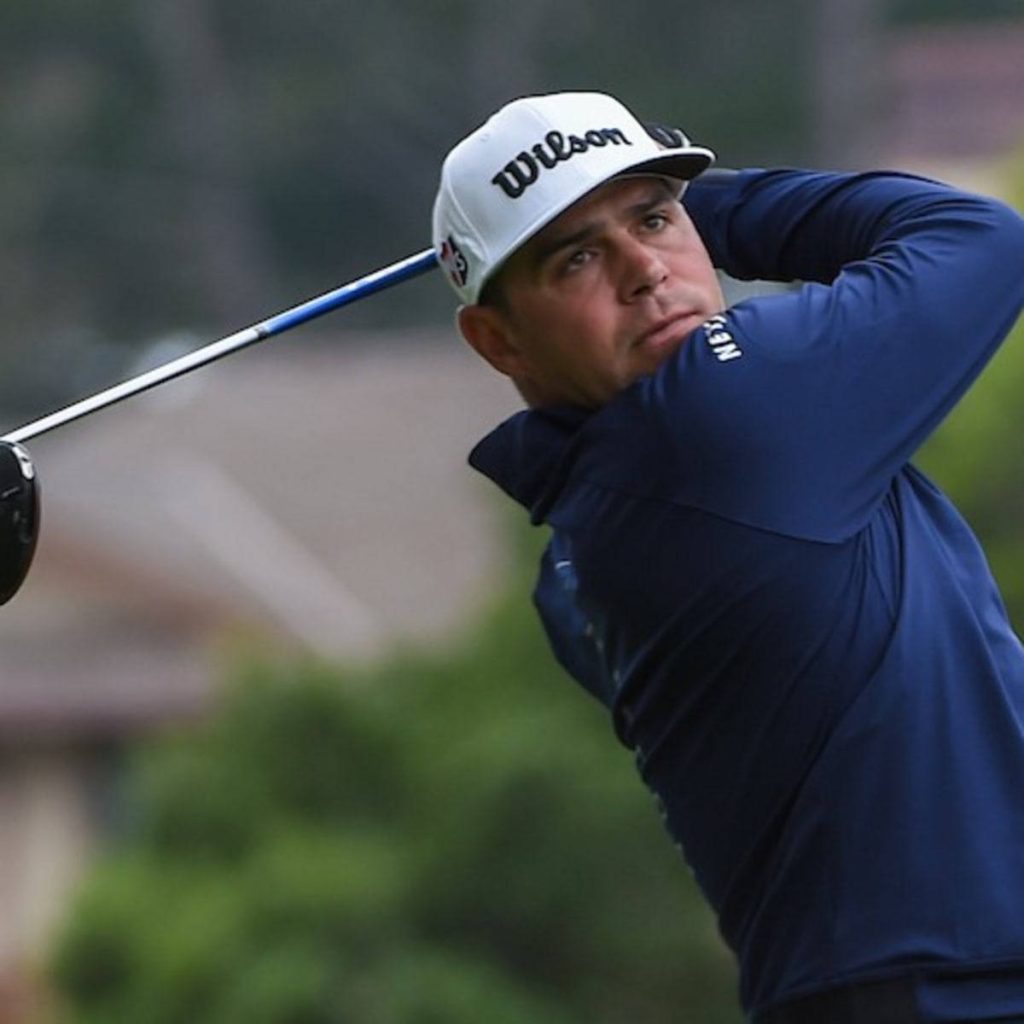 Gary Woodland mid-swing in white Wilson cap and navy shirt golf action wallpaper background