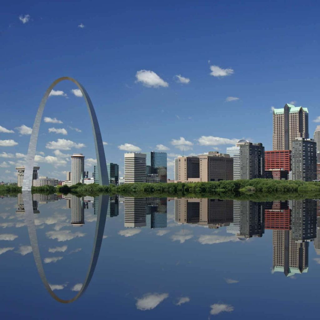 Gateway Arch St Louis skyline mirrored in calm water under bright blue sky urban architecture Wallpaper