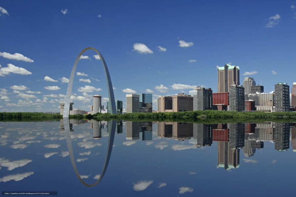 Gateway Arch and St Louis skyline reflected on calm river under blue sky with clouds wallpaper